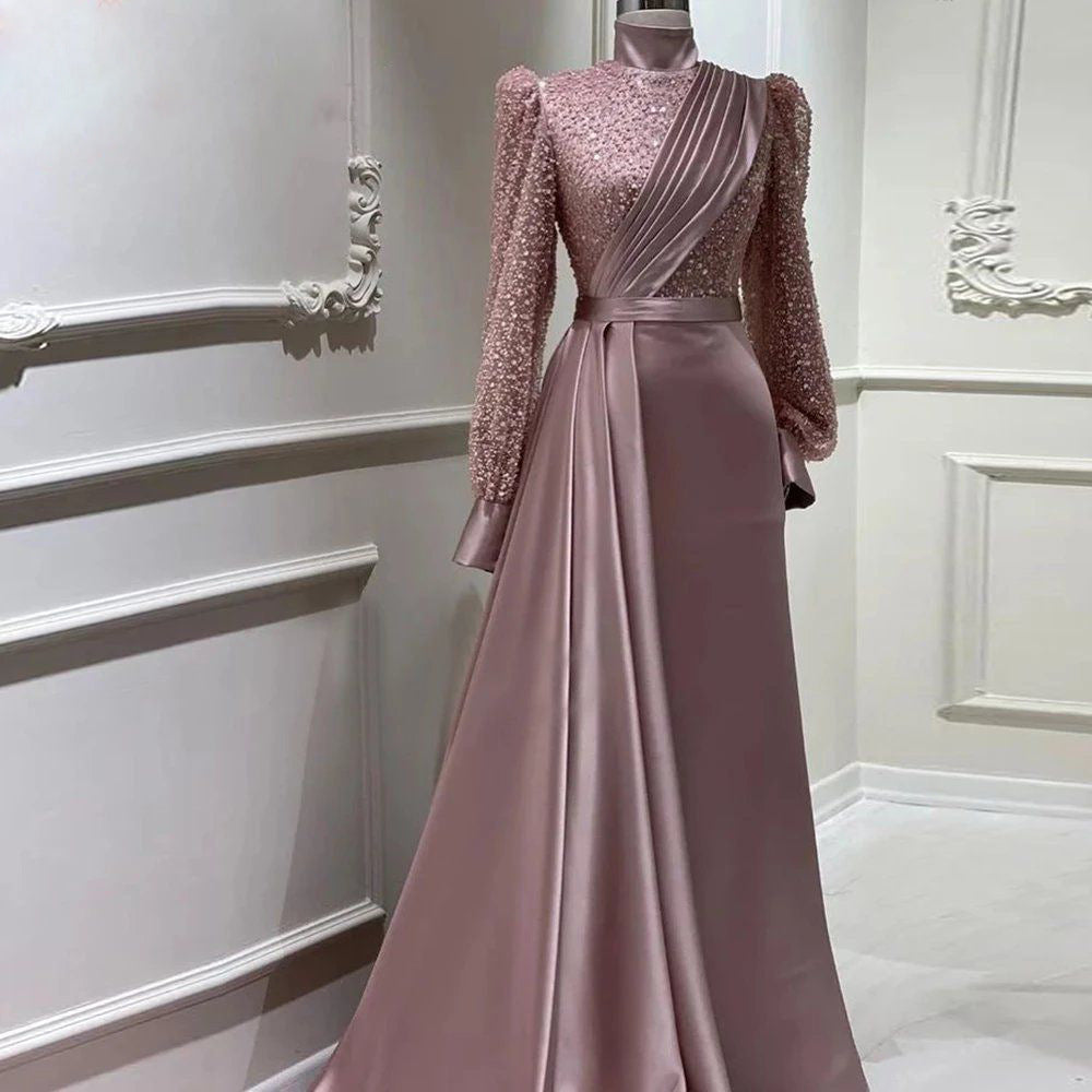 Beaded satin abaya evening dress featuring a stand collar and long sleeves in a soft pink color.